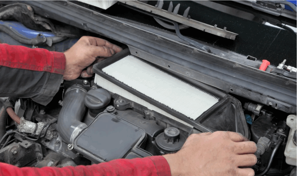Mechanic replacing a car engine air filter during maintenance